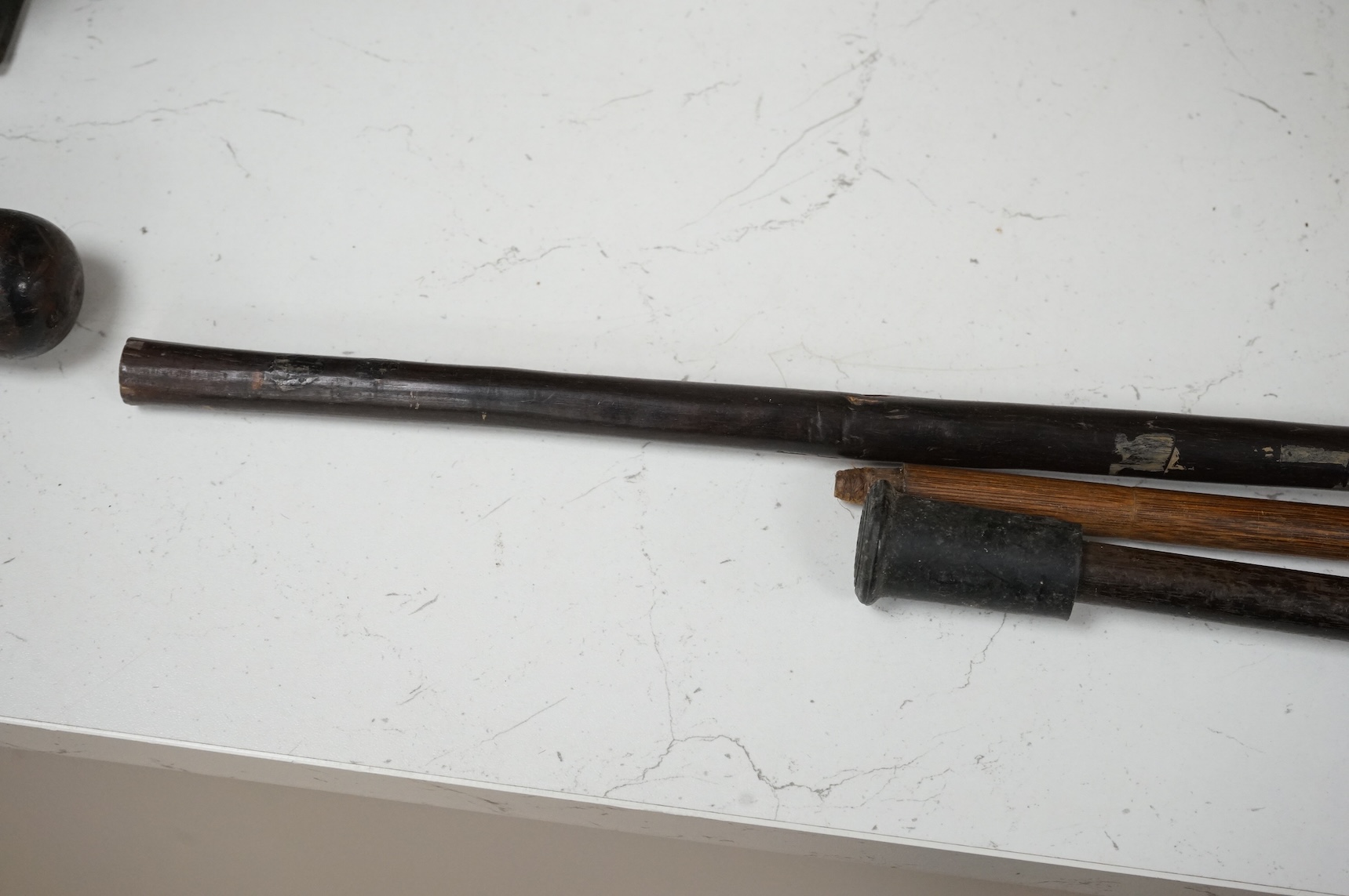 Two silver mounted walking sticks and a tribal carved ebony walking stick, longest 93cm